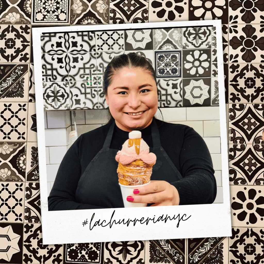 A woman holding a large churro filled with strawberry ice cream.