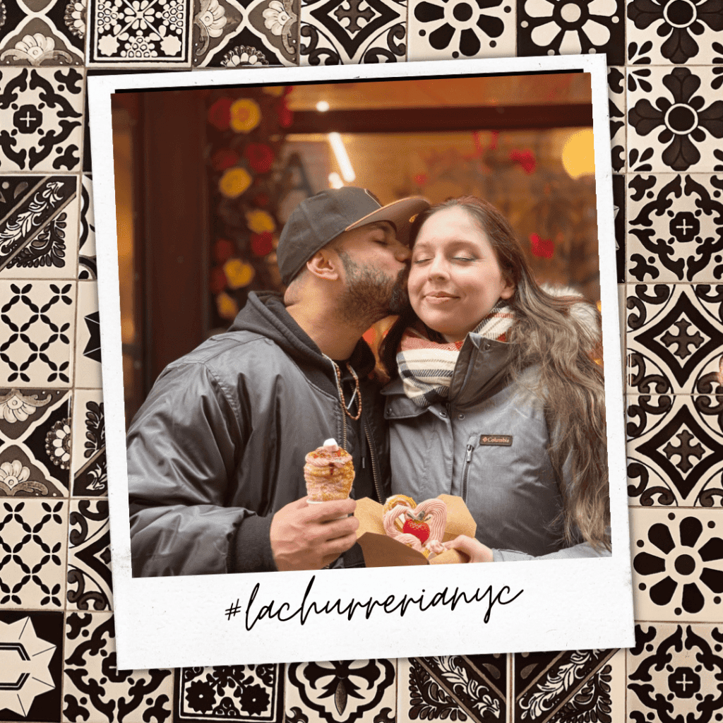 Two people smiling at the entrance of La Churrería NYC.
